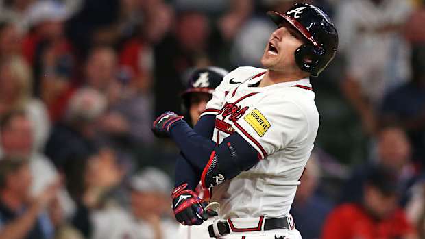 Austin Riley throws his arms crossed in front of his chest in celebration